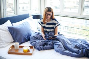 Woman sitting on a bed working