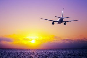 Photo of a plane flying at sunset