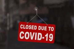 A store sign sayin closed due to COVID-19